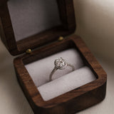 Diamond ring in a wooden box on a neutral background
